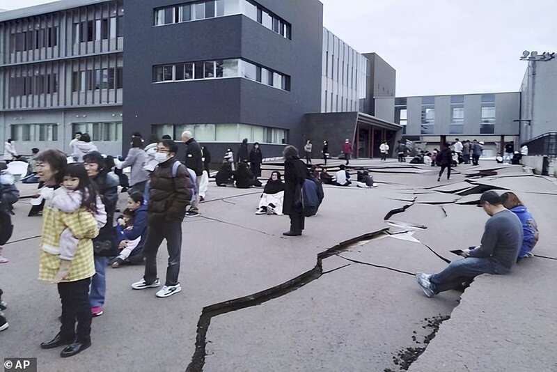 1月1日，在日本石川县轮岛市，人们站在被地震破坏的地面上
